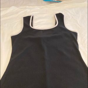 Black dress with white trim around neckline and arms. Polyester & spandex